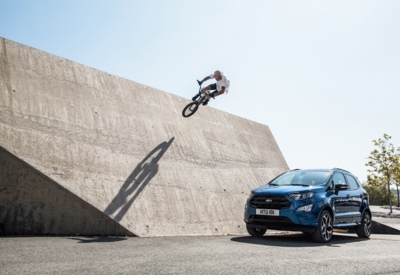 Ford Eco Sport neben Mauer, gegen die ein BMX Fahrer springt