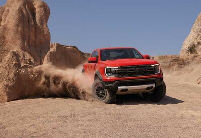 Roter Ford Ranger driftet in Wüste vor Felsen